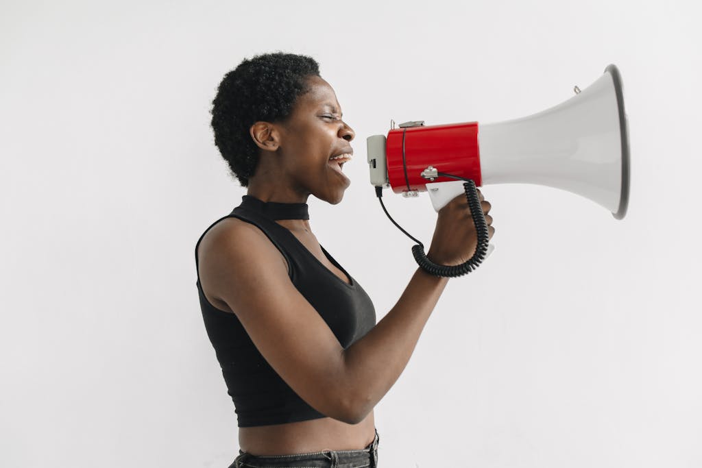 African American woman using a megaphone to protest, symbolizing activism and empowerment.