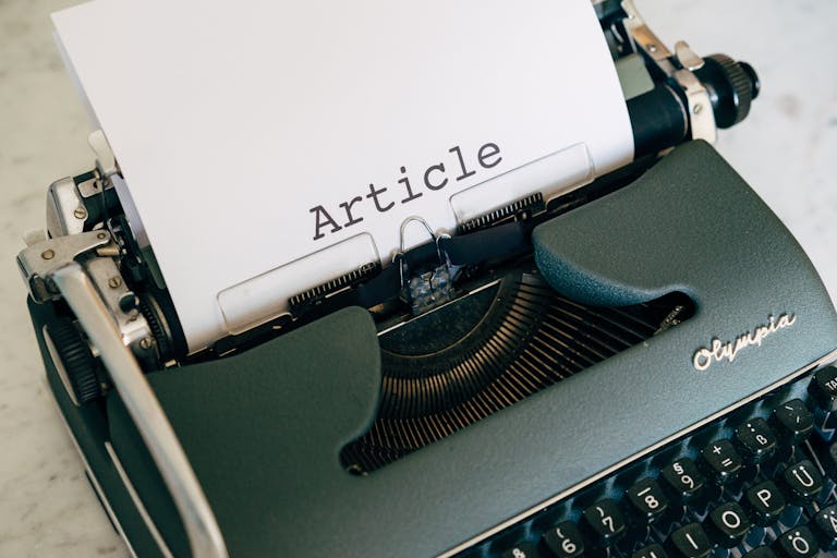 Top view of a vintage Olympia typewriter with paper titled 'Article'.
